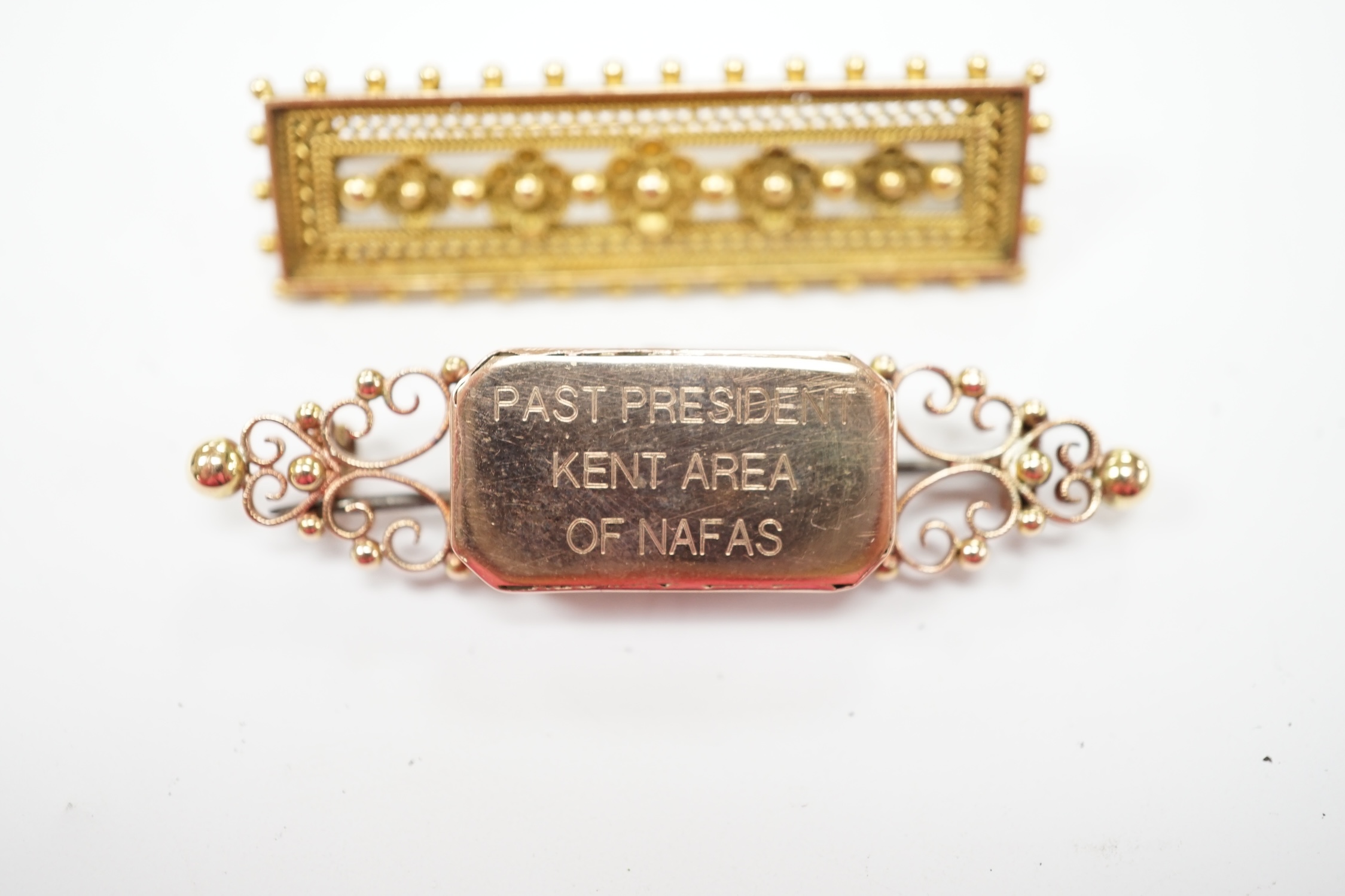 A late Victorian yellow metal cannetille work brooch, 45mm, 6.4 grams, together with a 15ct brooch, with later inscription, gross 6.2 grams. Fair condition.